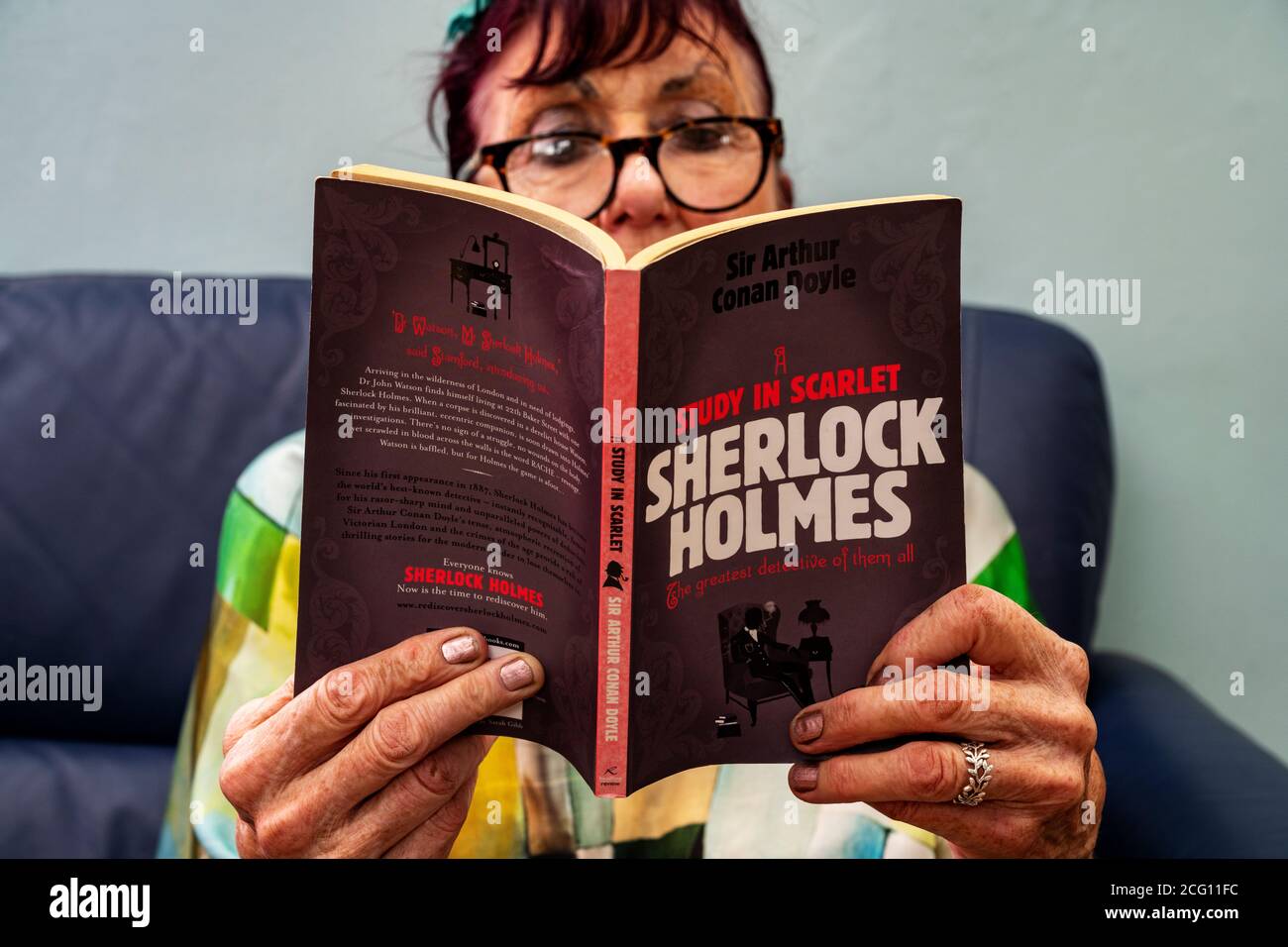 Ältere Frau, die Sherlock Holmes LIEST EINE Studie in Scharlach Stockfoto