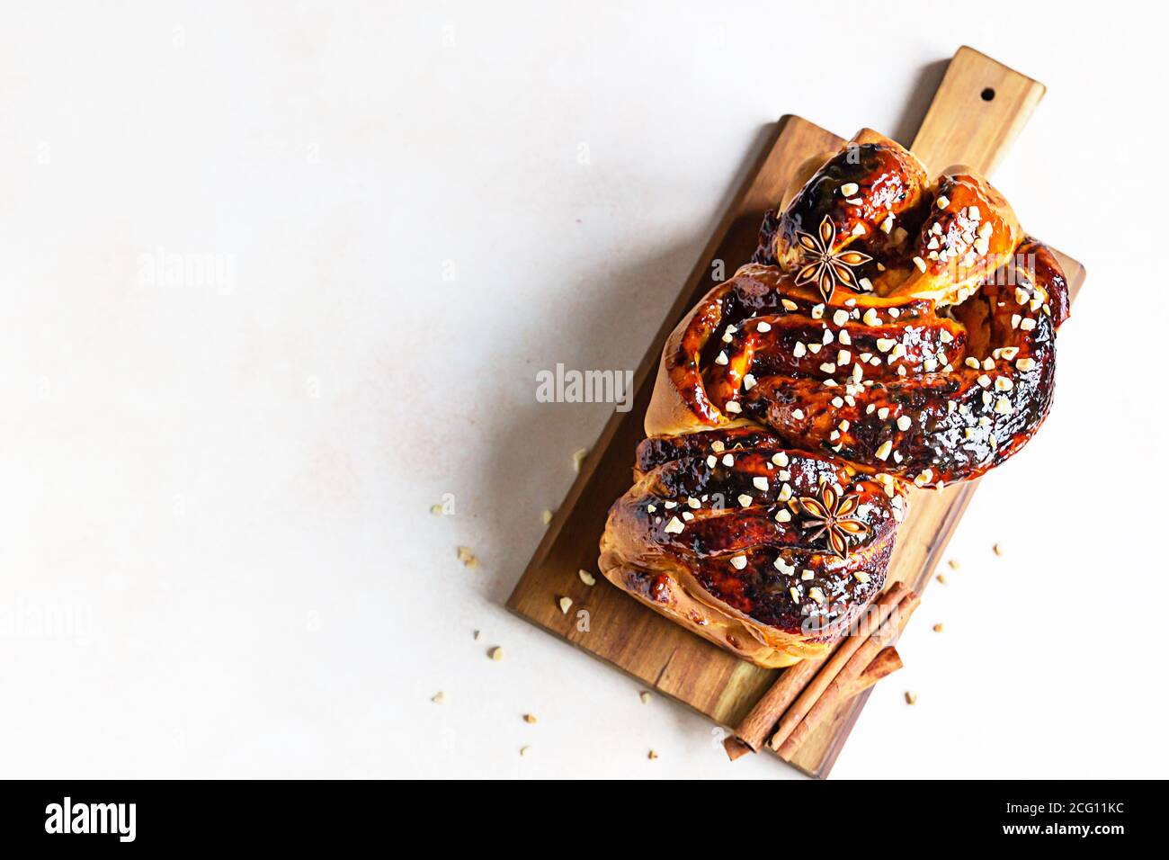 Babka oder Brioche Brot mit Aprikosenmarmelade und Nüssen. Hausgemachtes Gebäck zum Frühstück. Konkreter Hintergrund. Stockfoto