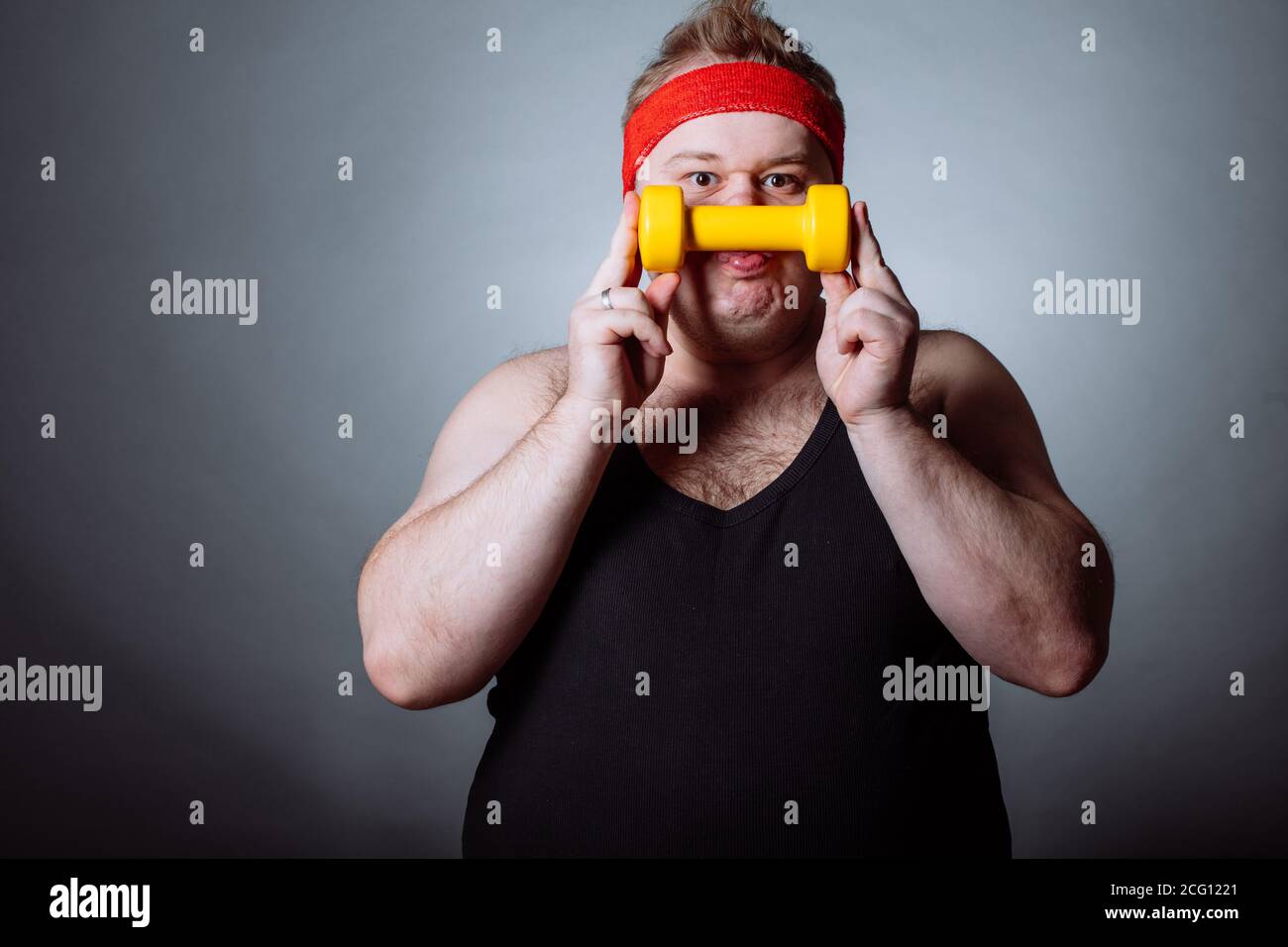 Fetter Mann mit schwarzen Shirt Training mit Hanteln und Kamera Stockfoto