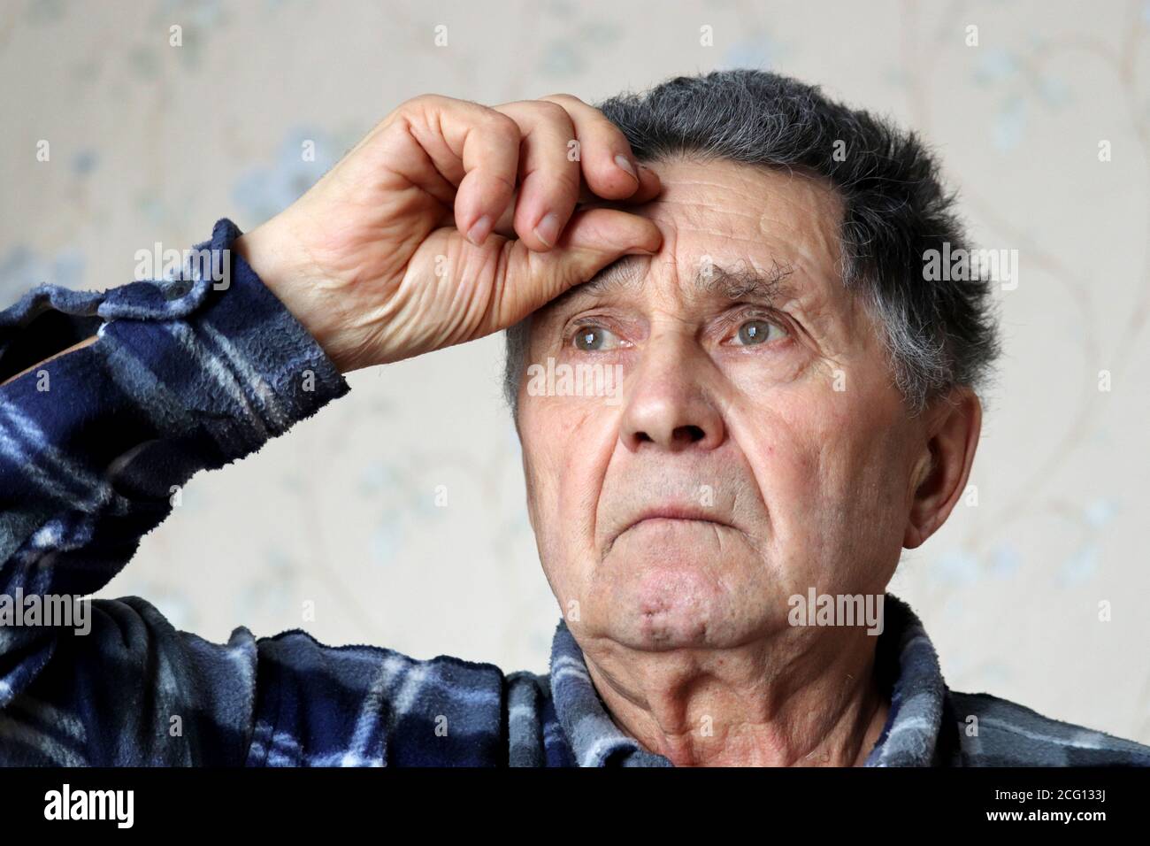 Coronavirus Symptome, älterer Mann legte seine Hand auf die Stirn. Krankes Männchen mit grauem Haar, Kopfschmerzen, Druck oder Kälte und Grippe Stockfoto