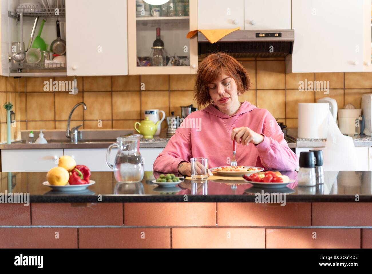 Junge hübsche Frau isst allein in ihrer Küche. Stockfoto