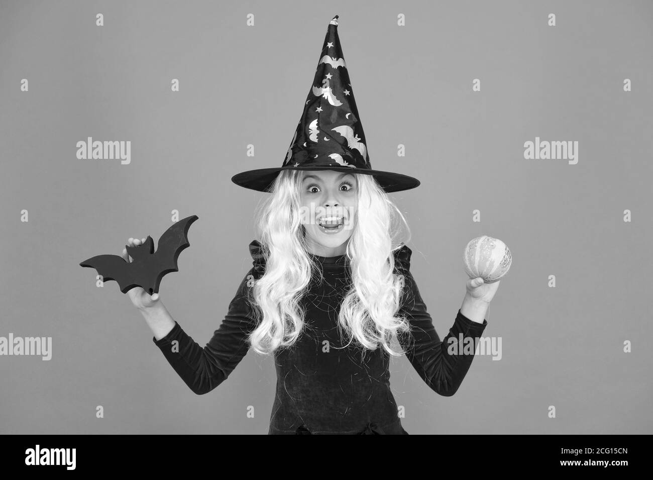 Freakishly wicked Halloween. Wenig böse Hexe Kind bat und Kürbis. Glückliches Mädchen tragen böse Hexe Kostüm. Kleine böse Zauberin mit modischen und schrecklich aussehen. Stockfoto