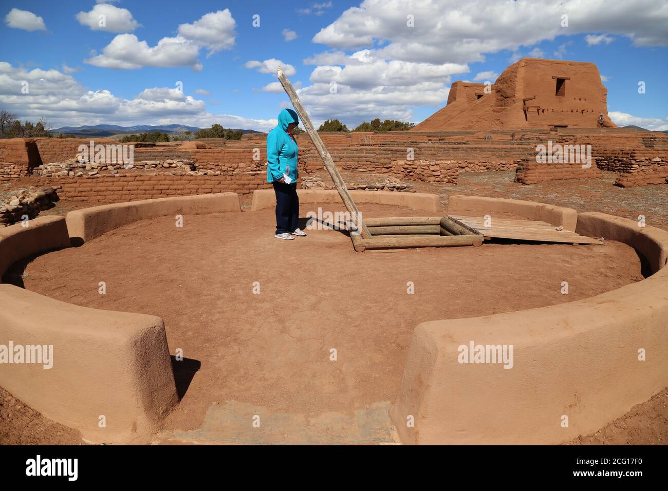 Unterirdische zeremonielle Kivas wurden für religiöse Aktivitäten verwendet. Ein Tourist blickt auf eine Kiva am Pueblo und Mission Ruins Trail bei Pecos Nati Stockfoto