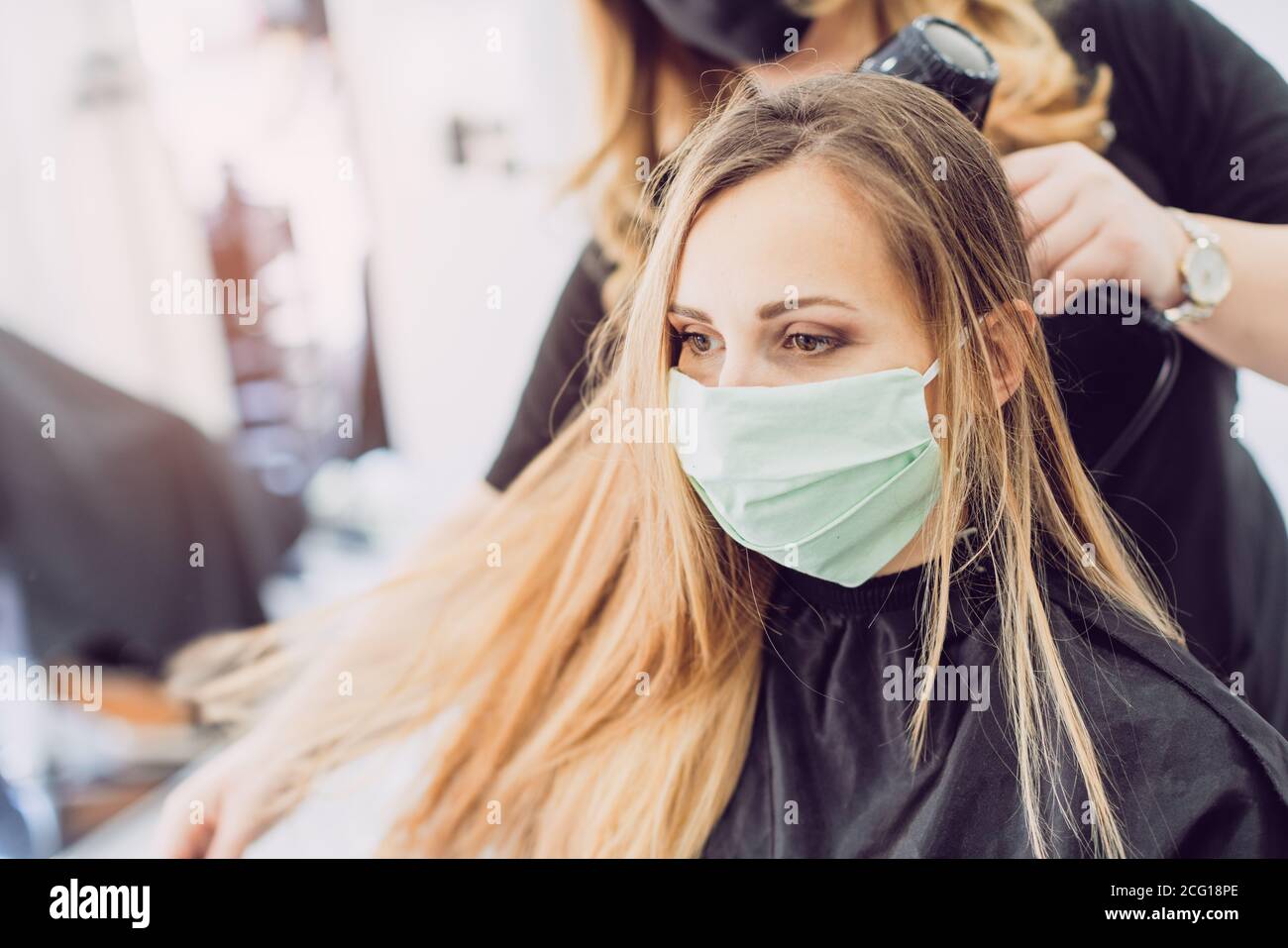 Friseur und Kunden waring Gesichtsmaske während Pandemie Stockfoto
