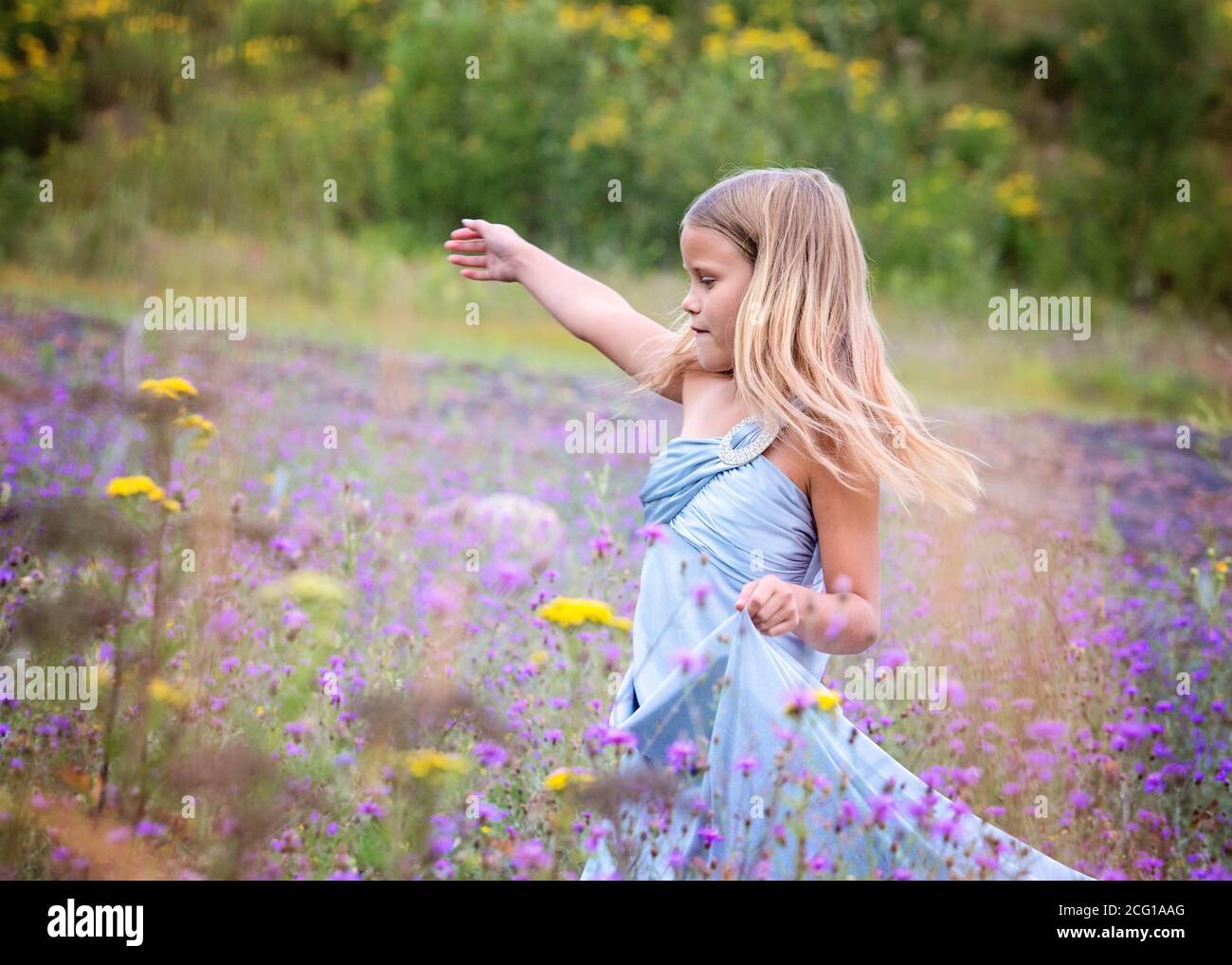 Junge Blonde Mädchen in einem Feld von Blumen Stockfoto