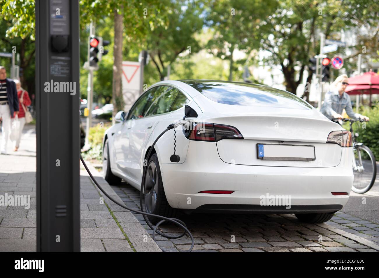 Elektroauto wird an einem speziellen Parkplatz mit einer elektrischen Batterieladestation aufgeladen. Stockfoto