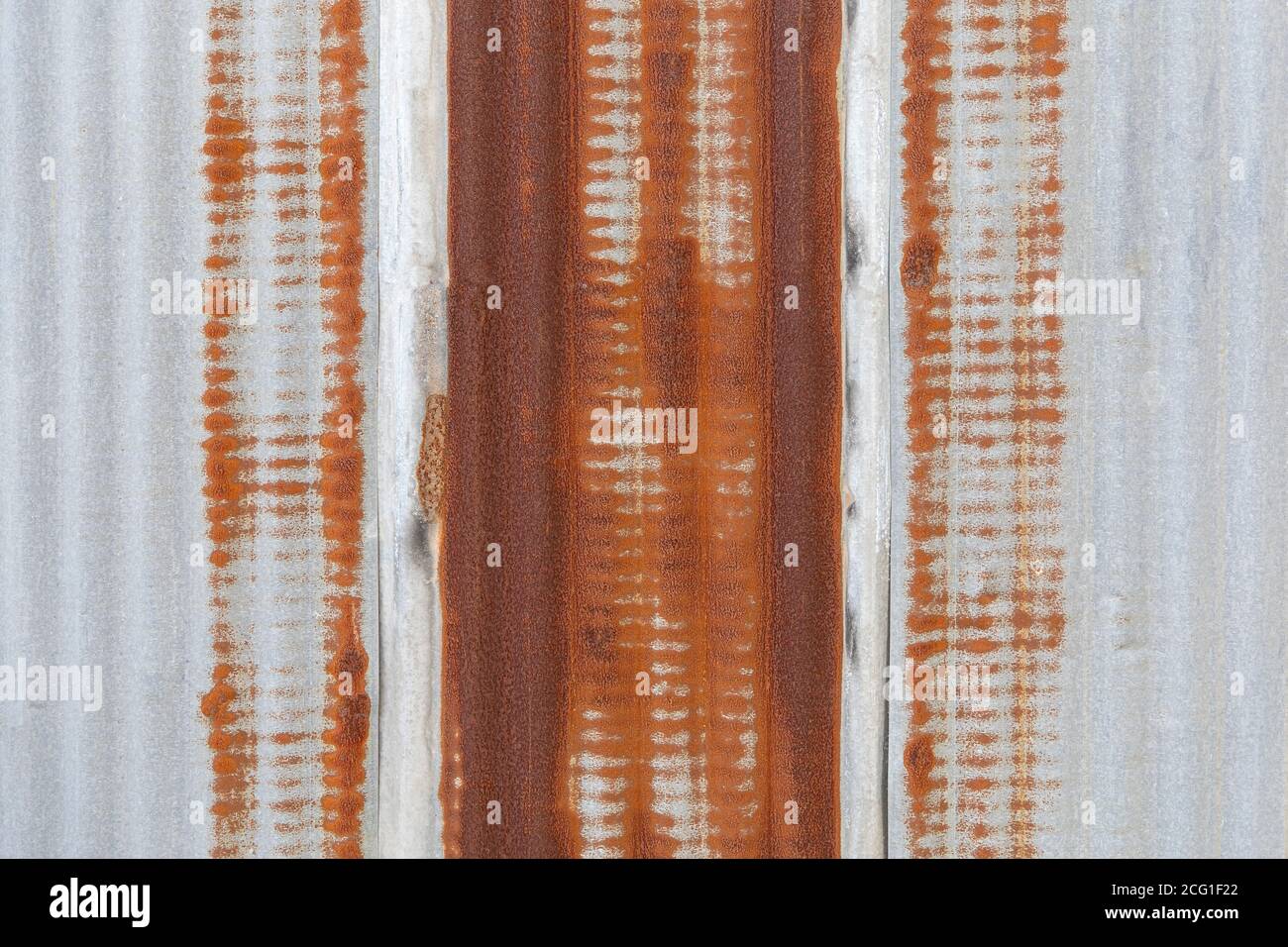 Verzinktes Wandpaneel mit Rostspuren auf dem verzinkten Blechhintergrund. Stockfoto