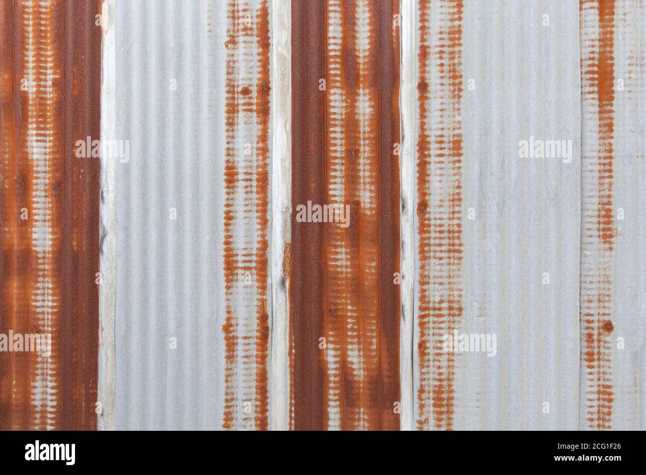 Verzinktes Wandpaneel mit Rostspuren auf dem verzinkten Blechhintergrund. Stockfoto