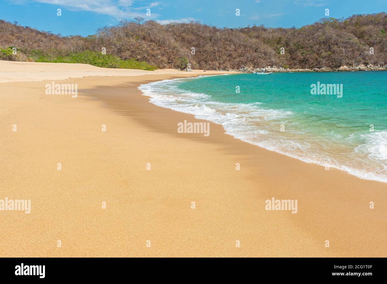Klassischer Blick auf eine Bucht und den Strand im Touristenort Huatulco am Pazifik während des Tages im Bundesstaat Oaxaca, Mexiko. Fokus auf Welle. Stockfoto