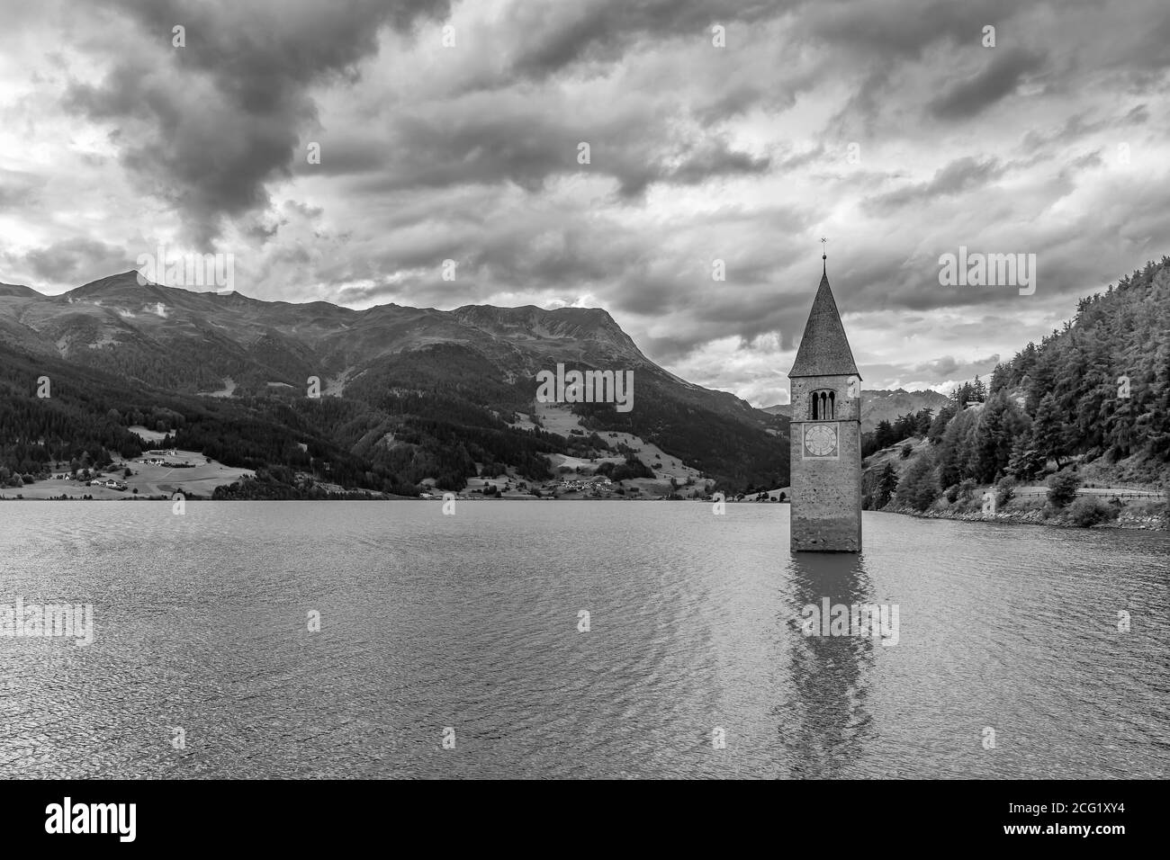Schöne Schwarz-Weiß-Ansicht der Spitze des alten Glockenturms von Graun, der aus dem Wasser des Reschensee, Südtirol, Italien, hervortritt Stockfoto