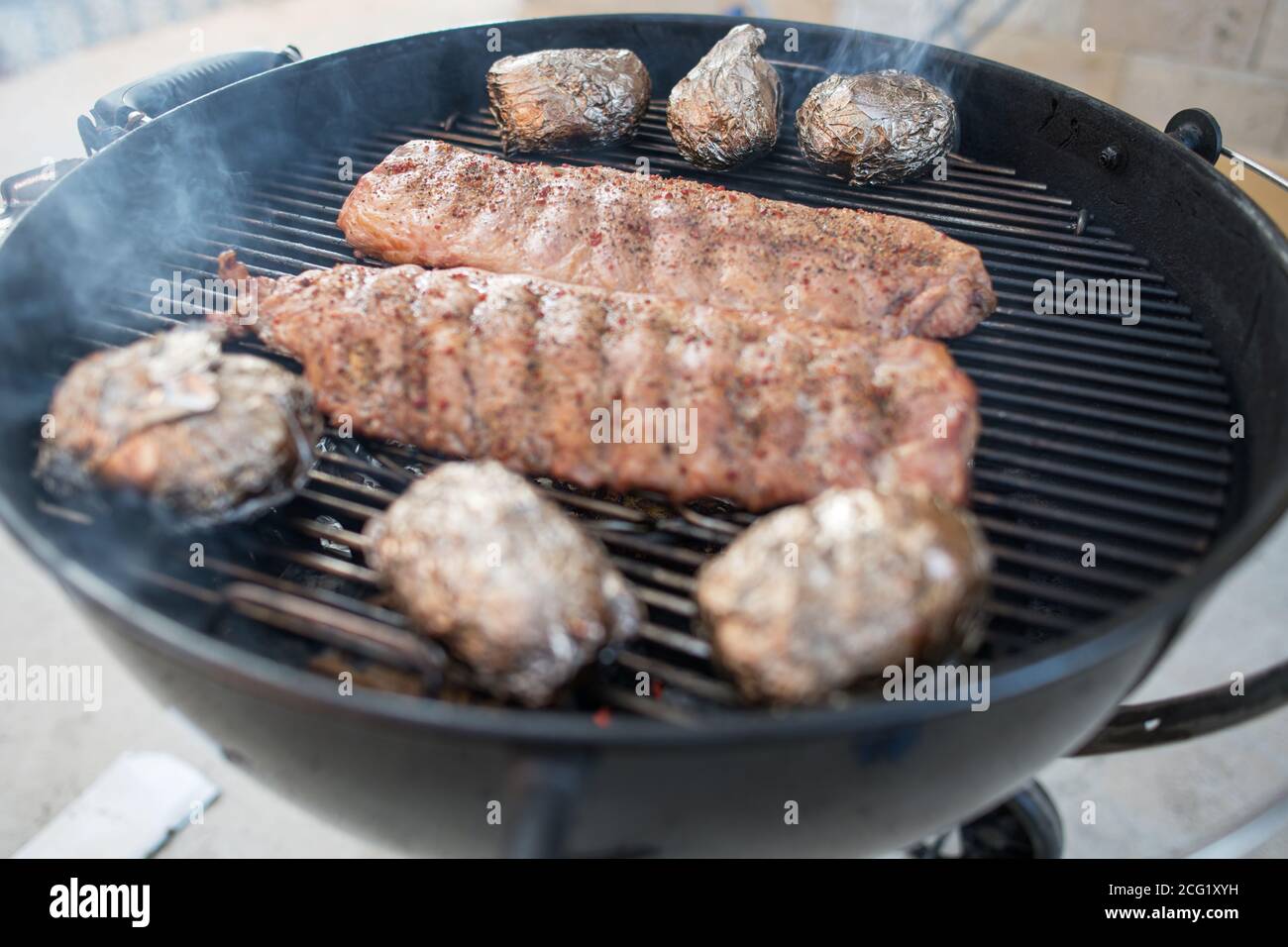 Schweineribs gebacken zu einem knackigen auf einem rauchigen Grill Stockfoto