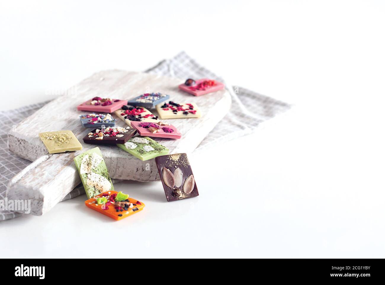 Natürliche belgische Schokolade mit verschiedenen Geschmacksrichtungen, aus Bio-Produkten, Matcha-Tee, grün, blau, Kokosnuss, bestreut mit Fruchtchips, Nüsse, Samen. Stockfoto