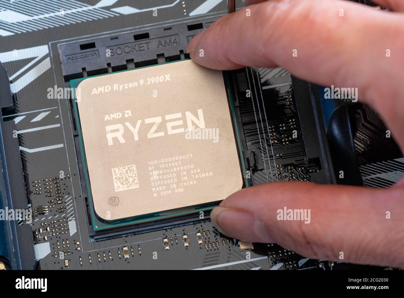 Nahaufnahme der Installation des Ryzen-Prozessors der dritten Generation auf dem Mainboard Stockfoto