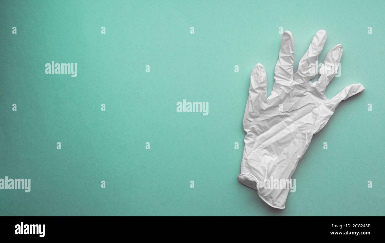 Weißer medizinischer Handschuh auf grünem elektrischem Hintergrund Stockfoto