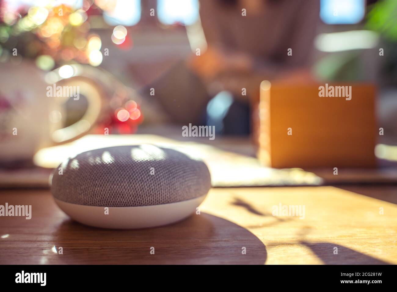 Frau im Gespräch mit Smart Speaker zu Hause Stockfoto