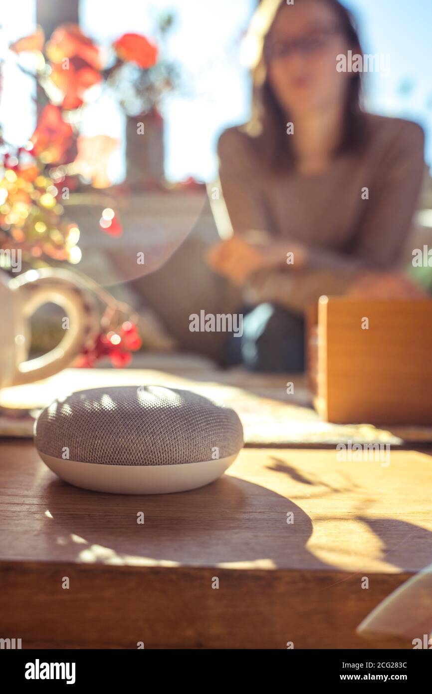 Frau im Gespräch mit Smart Speaker zu Hause Stockfoto
