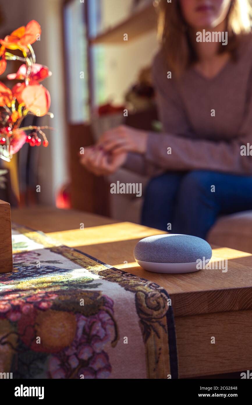 Frau im Gespräch mit Smart Speaker zu Hause Stockfoto