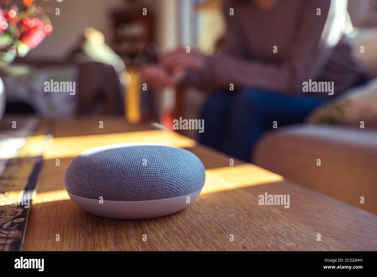 Frau im Gespräch mit Smart Speaker zu Hause Stockfoto