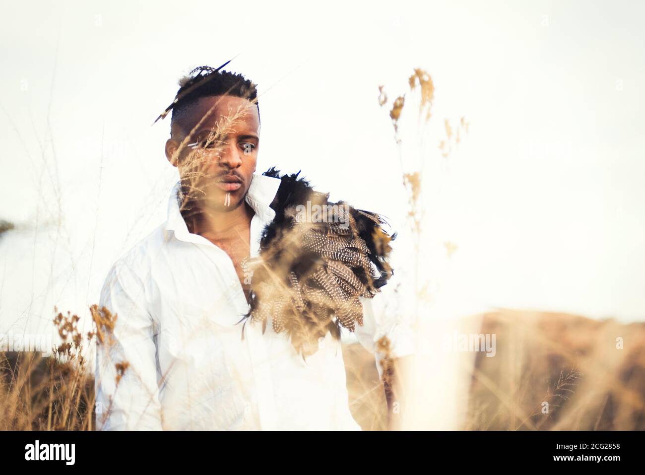 afrikanischer Gentleman im afrikanischen Busch mit Buschhut in Das Gras Stockfoto