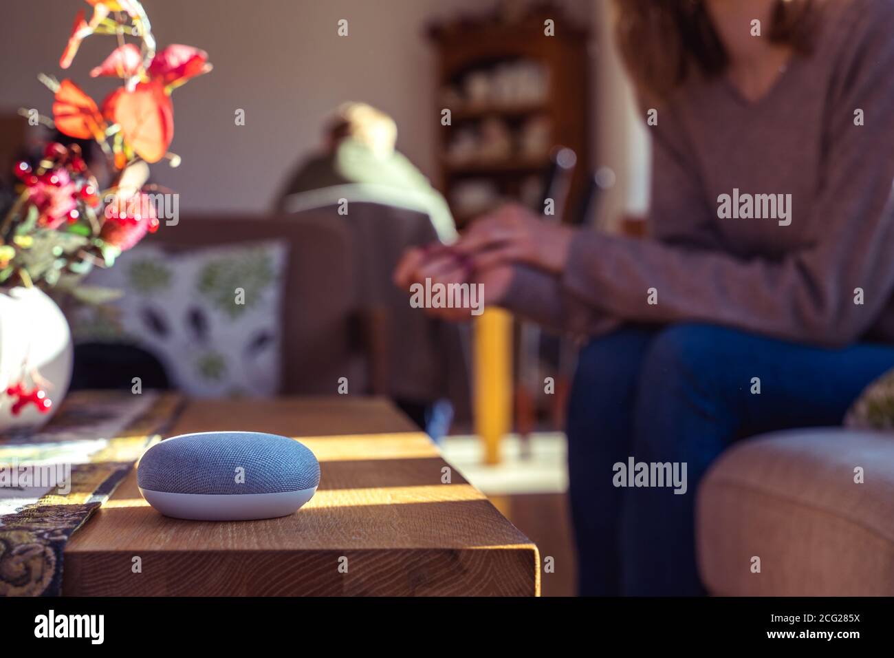 Frau im Gespräch mit Smart Speaker zu Hause Stockfoto