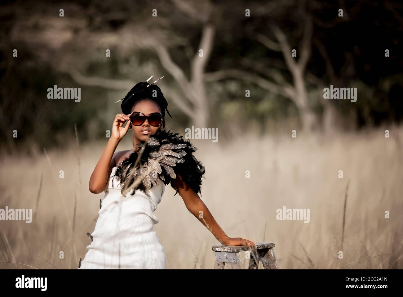 Erfolgreiches schwarzes Frauenmodell in afrikanischer Safari mit Sonnenbrille Stockfoto