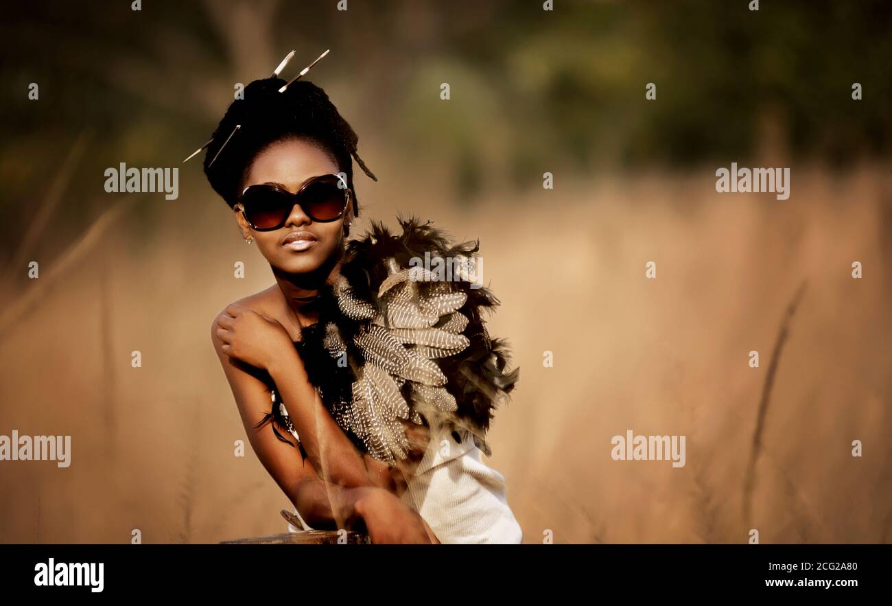 Erfolgreiches schwarzes Frauenmodell in afrikanischer Safari mit Sonnenbrille Stockfoto