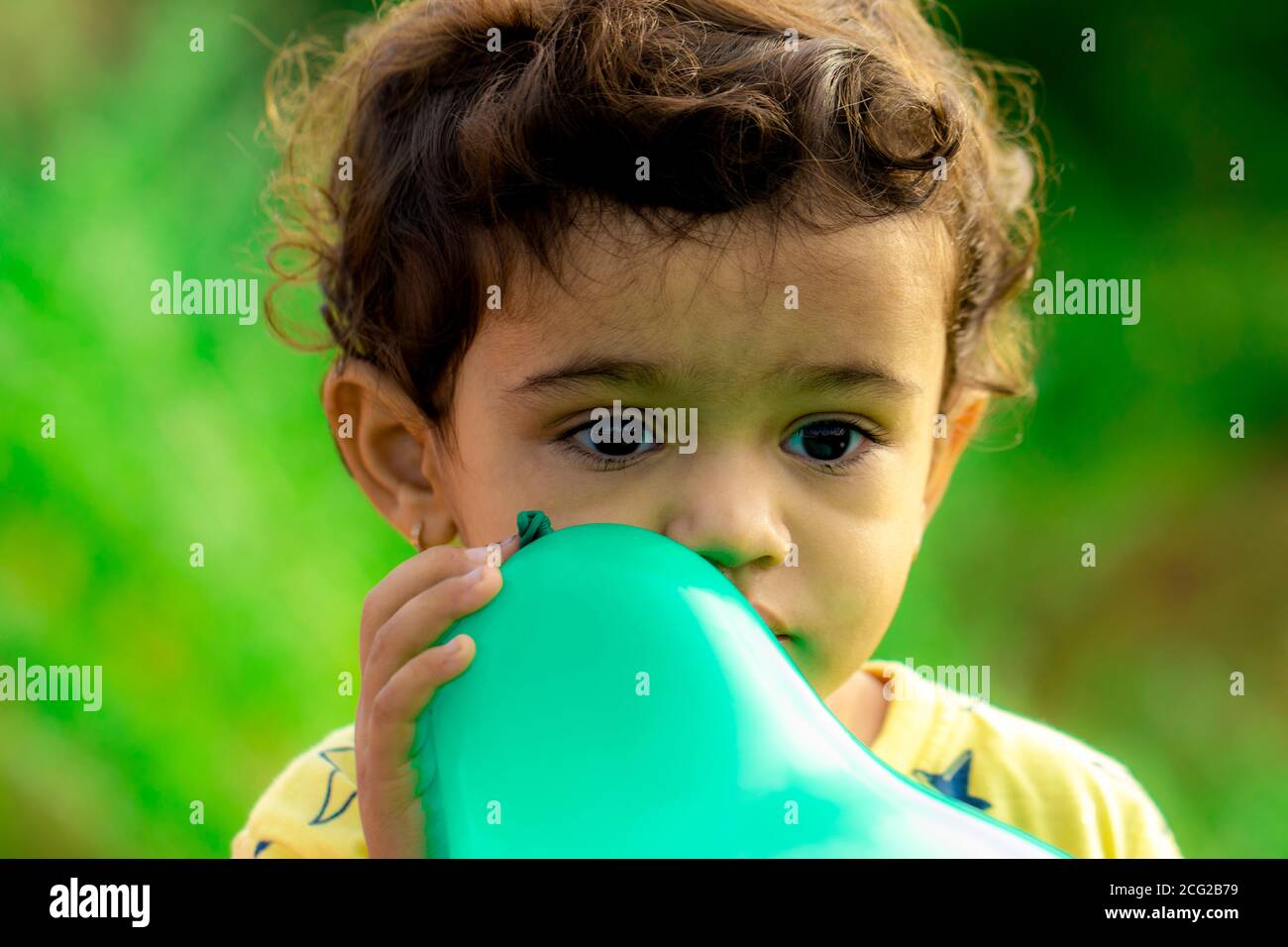Ein kleines Kind hält einen blauen Ballon und denkt an seinen Problem Stockfoto