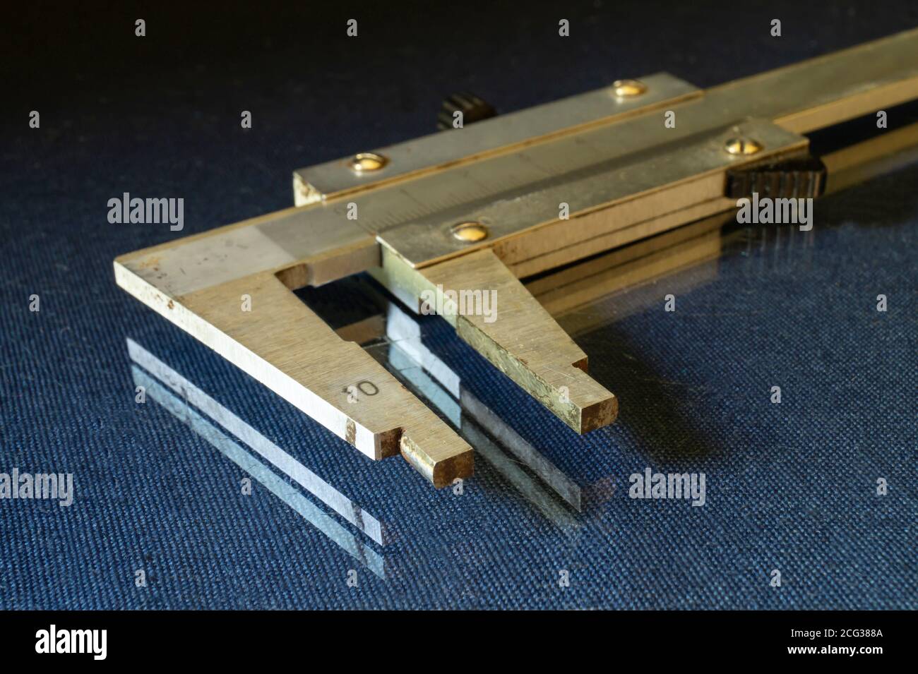 Bremssattel ruht auf Glastisch auf schwarzem Hintergrund.Instrument für genau Messung der Details Stockfoto