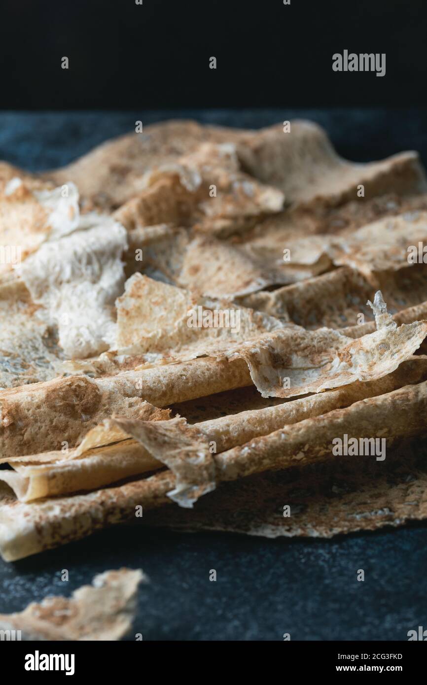 Hausgemachtes dünnes armenisches Pita-Brot (Lavasch) liegt auf einem dunkelblauen Steingrund. Selektiver Fokus. Stockfoto