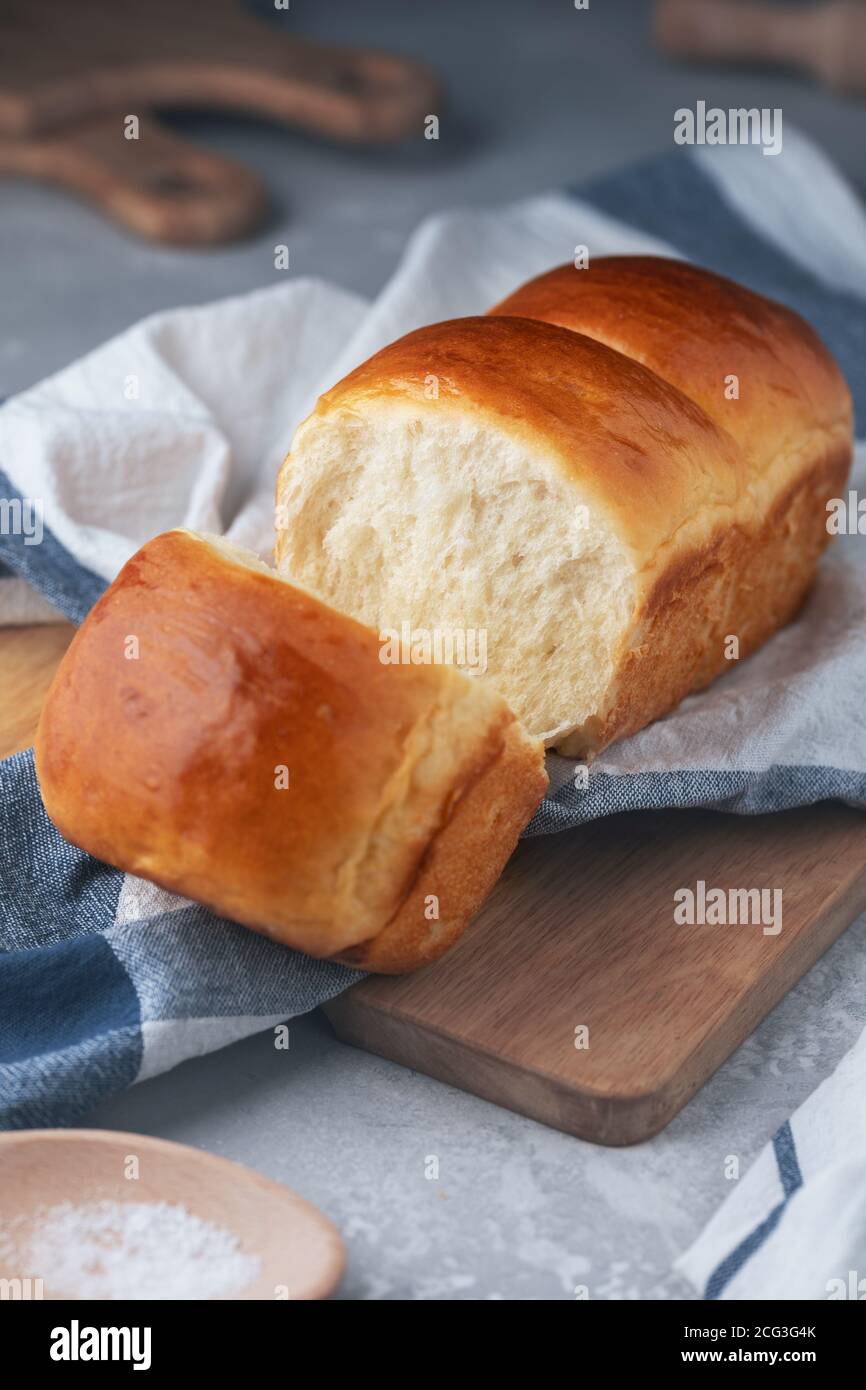 Frisch gebackenes hausgemachtes Hokkaido Milchbrot auf dem Küchentuch. Japanisches weiches und flauschiges Brot. Kochen zu Hause. Selektiver Fokus. Stockfoto