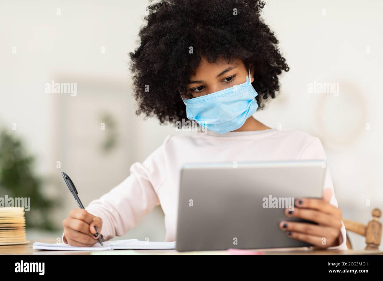 African American Kid In Maske Mit Tablet Learning Zu Hause Stockfoto