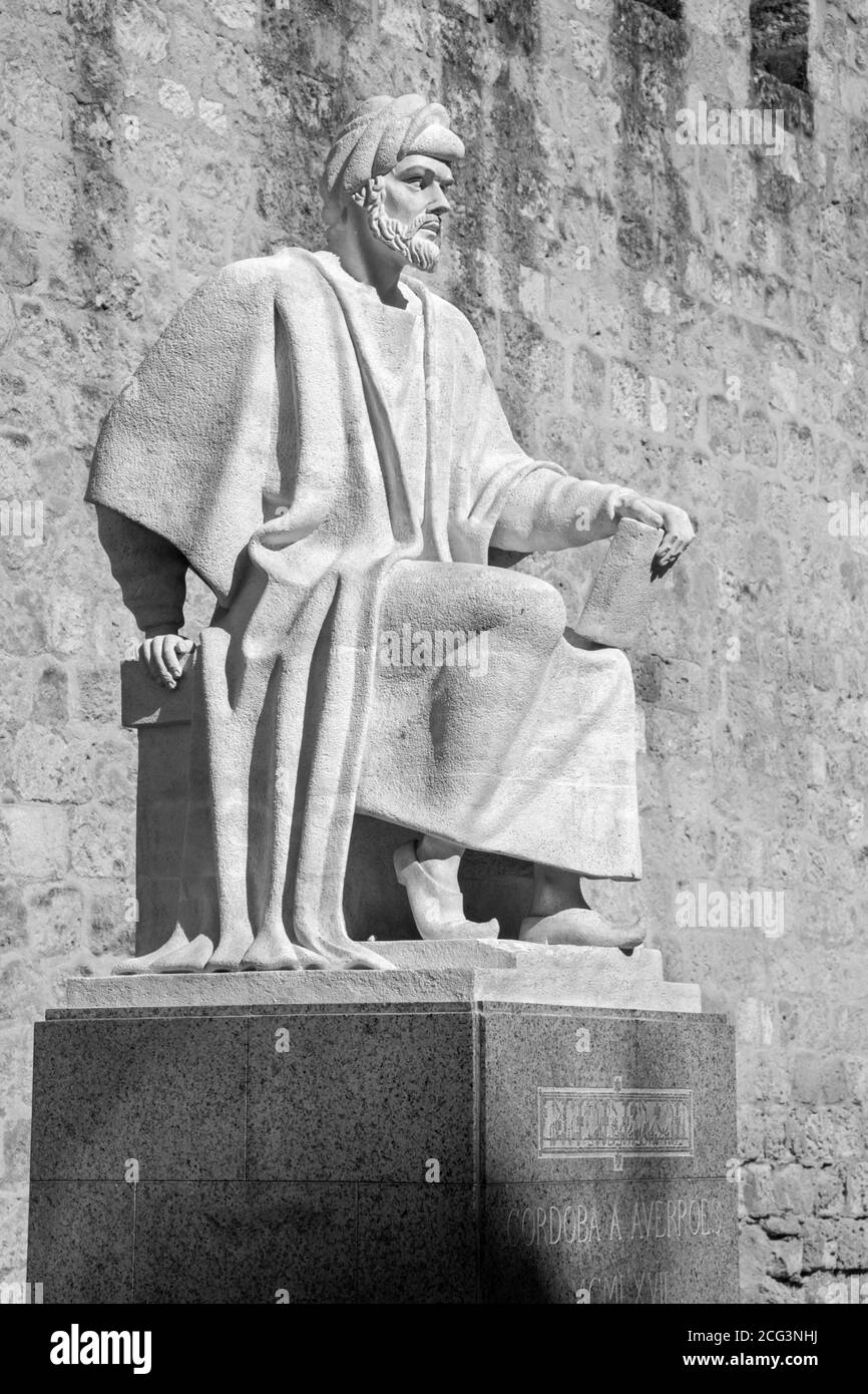 Córdoba, Spanien – 25. Mai 2015: Die Statue des mittelalterlichen arabischen Philosophen Averroes von Pablo Yusti Conejo (1967) und der mittelalterlichen Stadtmauer. Stockfoto