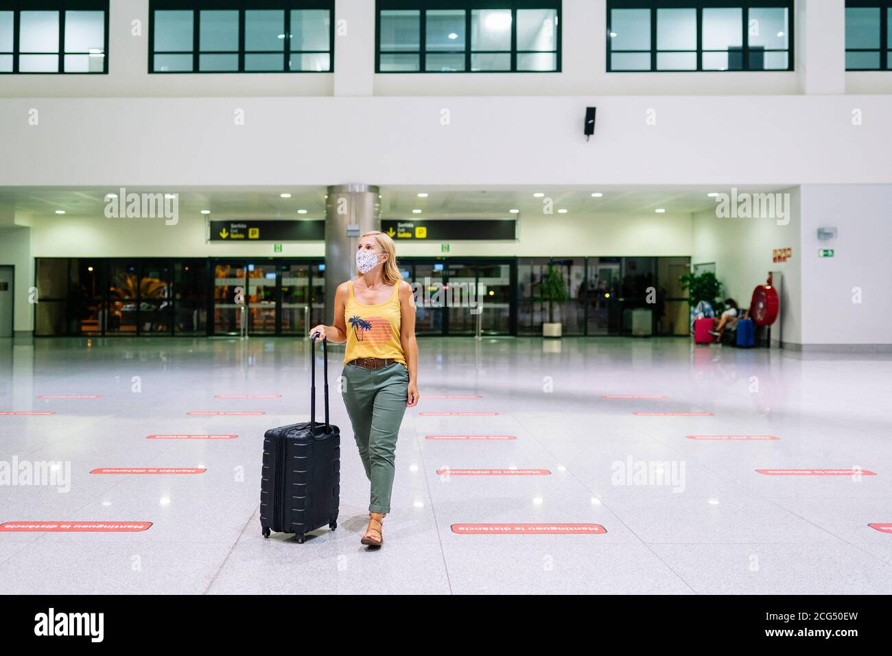Eine Frau am Flughafen mit Koffer Stockfoto