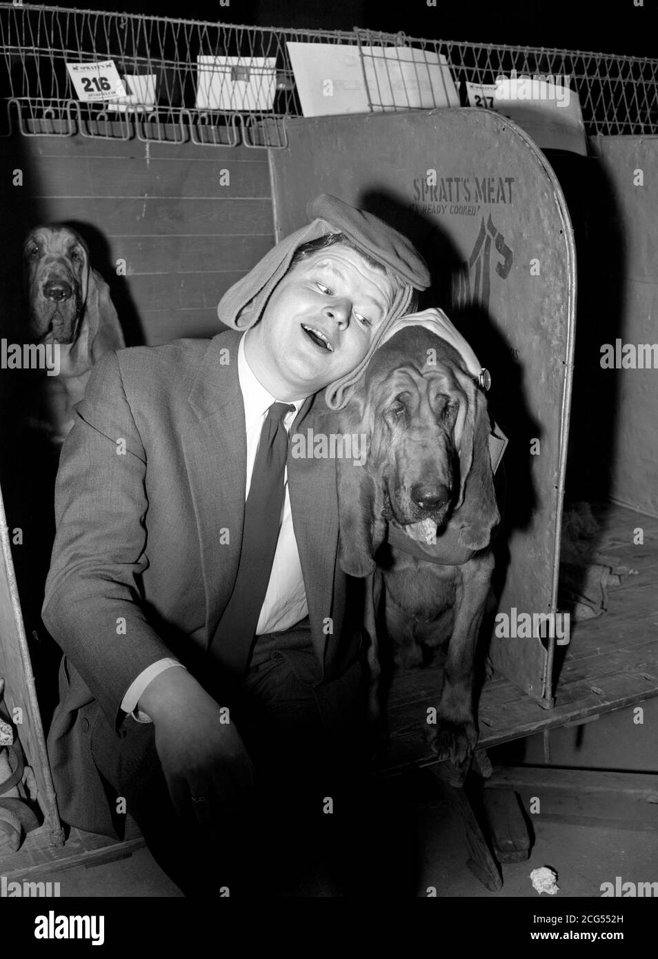 Benny Hill, mit Bloodhound Hector, gespielt von Bennys Hund 'Fabian', in seinem Comedy-Film 'Who Done IT?'. Im Film spielt Benny einen Privatdetektiv bei der Cruft's Dog Show in Olympia, London. Stockfoto