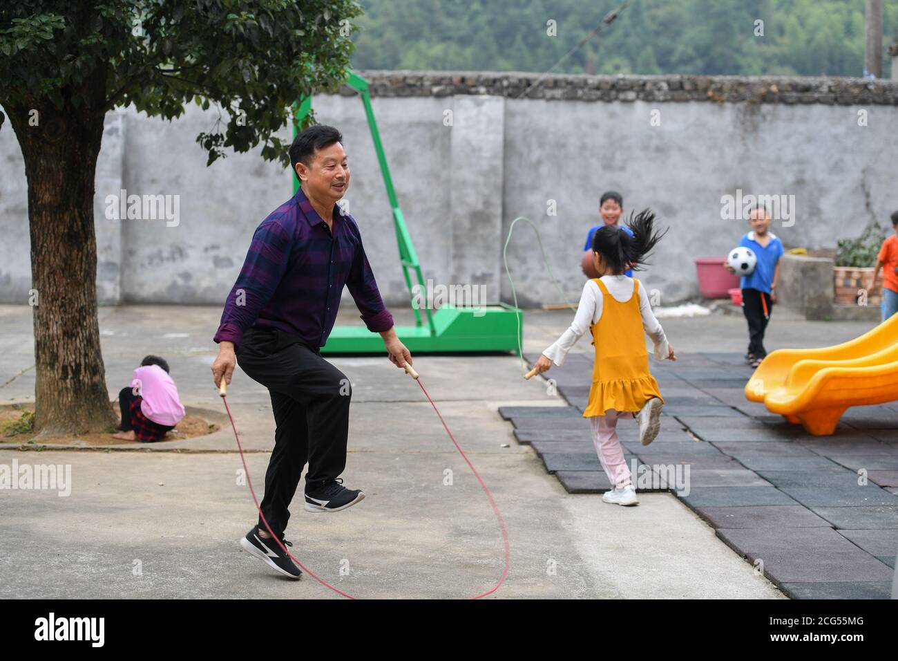 (200909) -- CHANGSHA, 9. September 2020 (Xinhua) -- Dong Zhuwen (2. L) spielt mit Schülern während einer Klassenpause an der Chagan Grundschule in der Gemeinde Huju im Bezirk Chaling, Provinz Hunan in Zentralchina, 8. September 2020. Dong Zhuwen, 63, ist Lehrer für Schüler der ersten und zweiten Klasse an der Chagan Primary School. Geboren in Huju Township, begann Dong Zhuwen seine Lehrtätigkeit hier im Jahr 1977. Nach seiner Pensionierung im Jahr 2017, entschied er sich für den Aufenthalt in der Schule und weiterhin Unterricht, da die Schule war in Mangel an Lehrern. "Ich mag Kinder, ich möchte für sie bleiben", sagte Dong. Er hofft auch, dass mehr Stockfoto