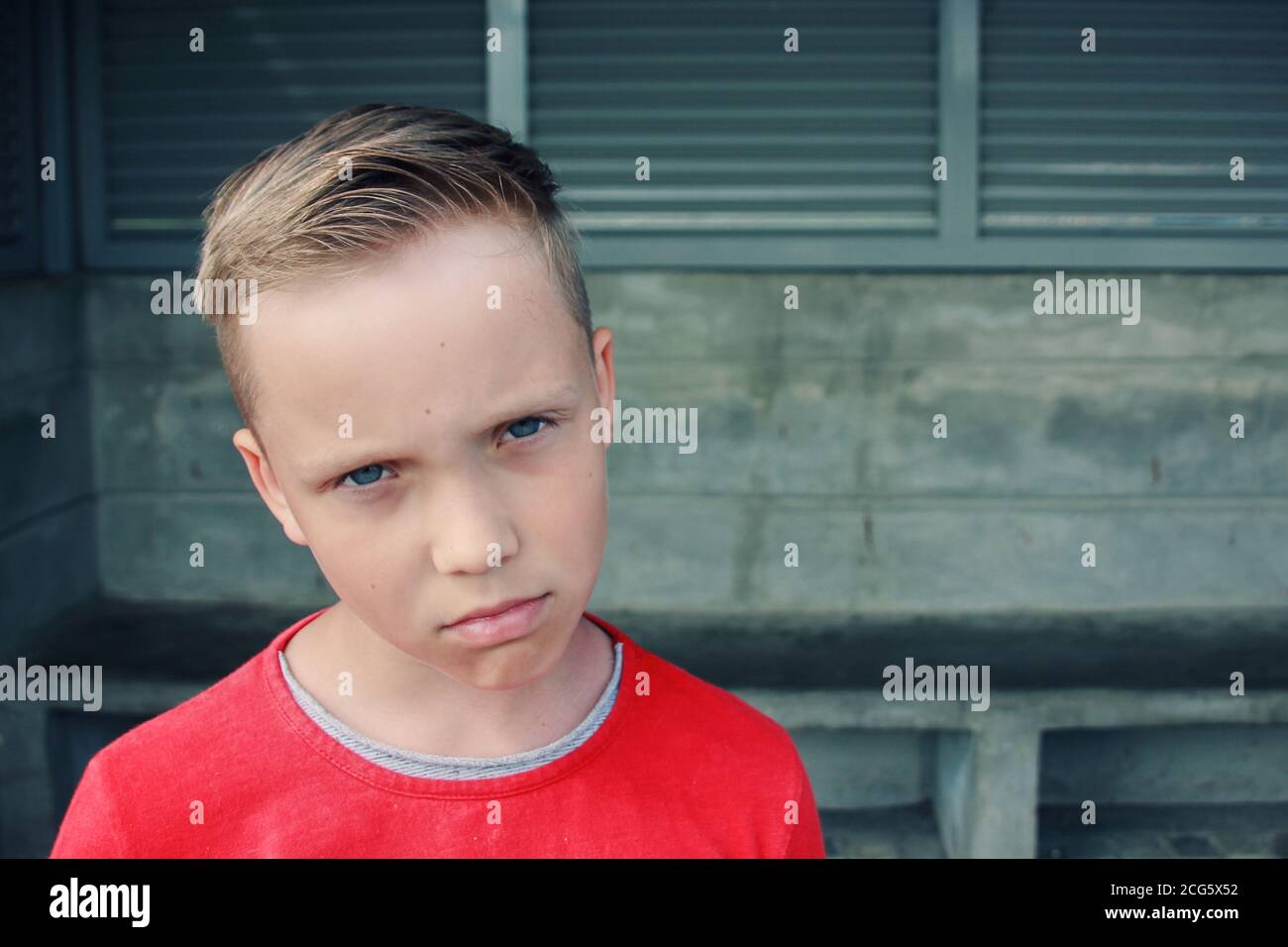 Niedliche kleine blauäugige europäische blonde Junge sieht traurig und frustriert. Er schaut mit Trauer nachdenklicher Ausdruck in seinem Gesicht.emotionaler Ausdruck Gesicht. Stockfoto