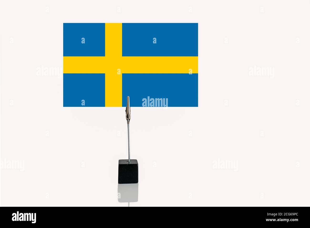 Konstitutionelle Monarchie und eine parlamentarische Demokratie von Schweden Miniatur-Flagge In Würfelbasis in Fotohalter auf weißem Hintergrund Stockfoto