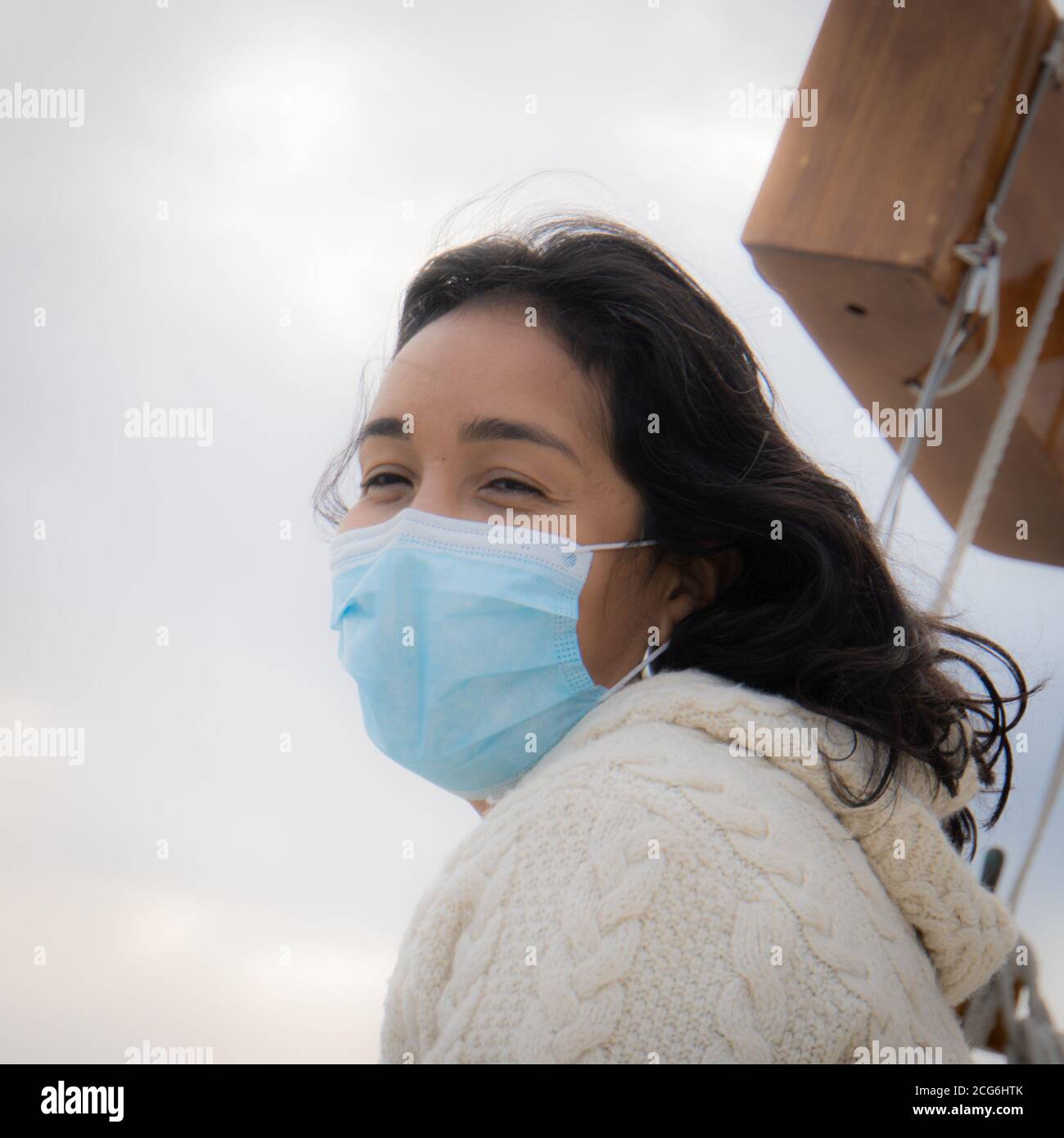 Junge Frau trägt Maske genießen Segeln in der Zeit der Die Covid-19-Pandemie Stockfoto
