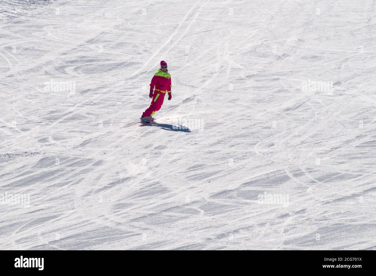 Frau reitet auf einem Snowboard auf einem Berghang. Stockfoto