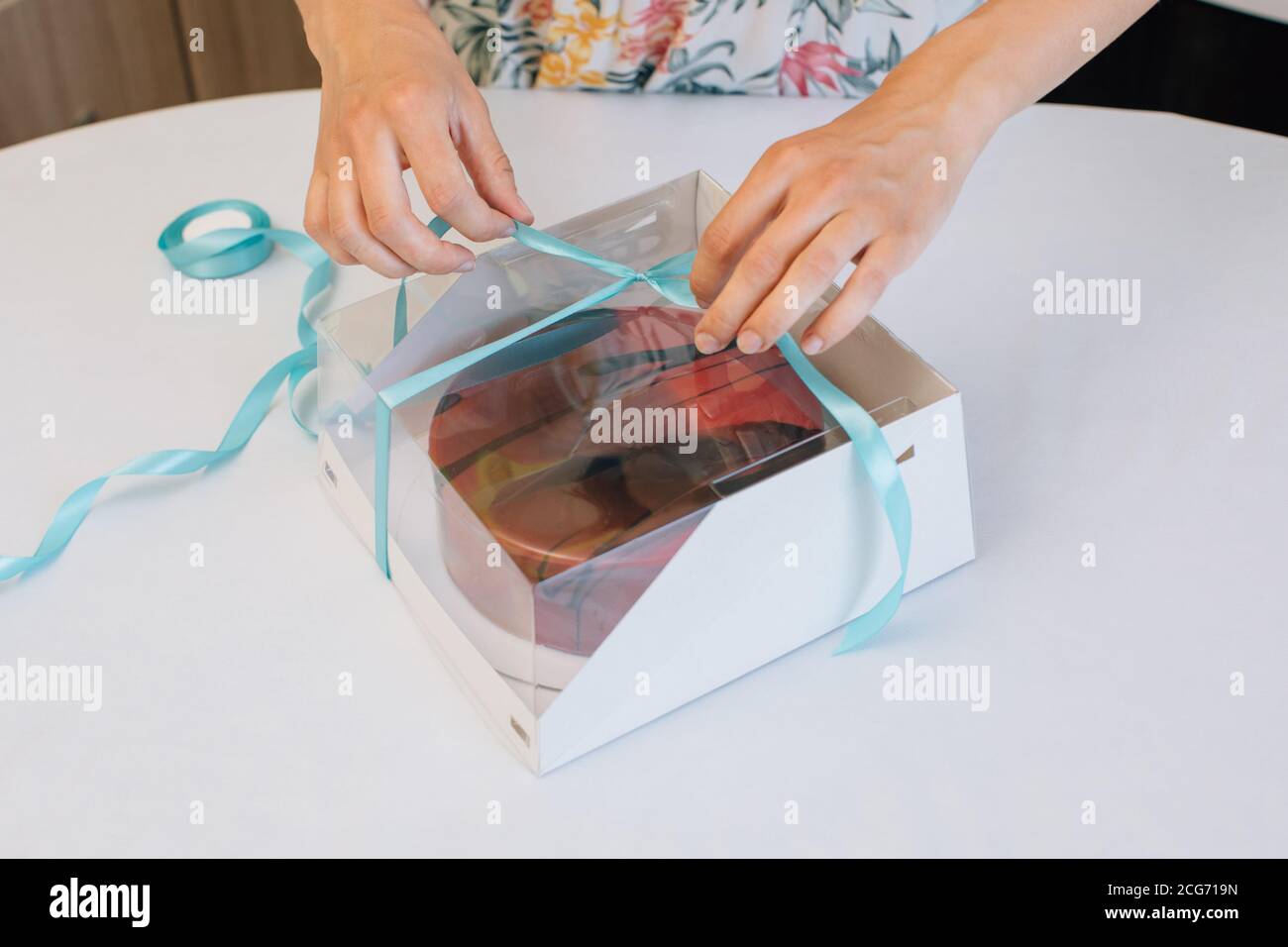 Frau Verpackung hausgemachten Kuchen in einer Geschenkbox Stockfoto