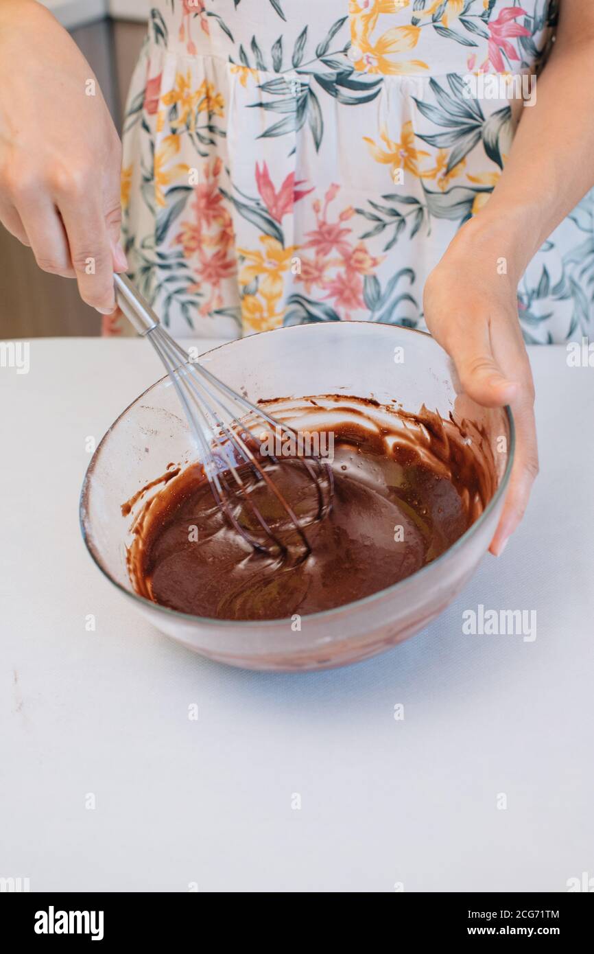 Frau steht in der Küche Whisking Kuchen Teig Stockfoto