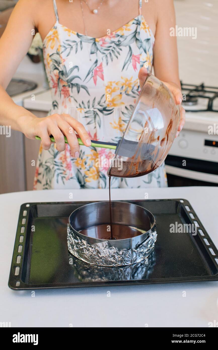 Frau gießt Kuchenteig in eine Kuchenform Stockfoto