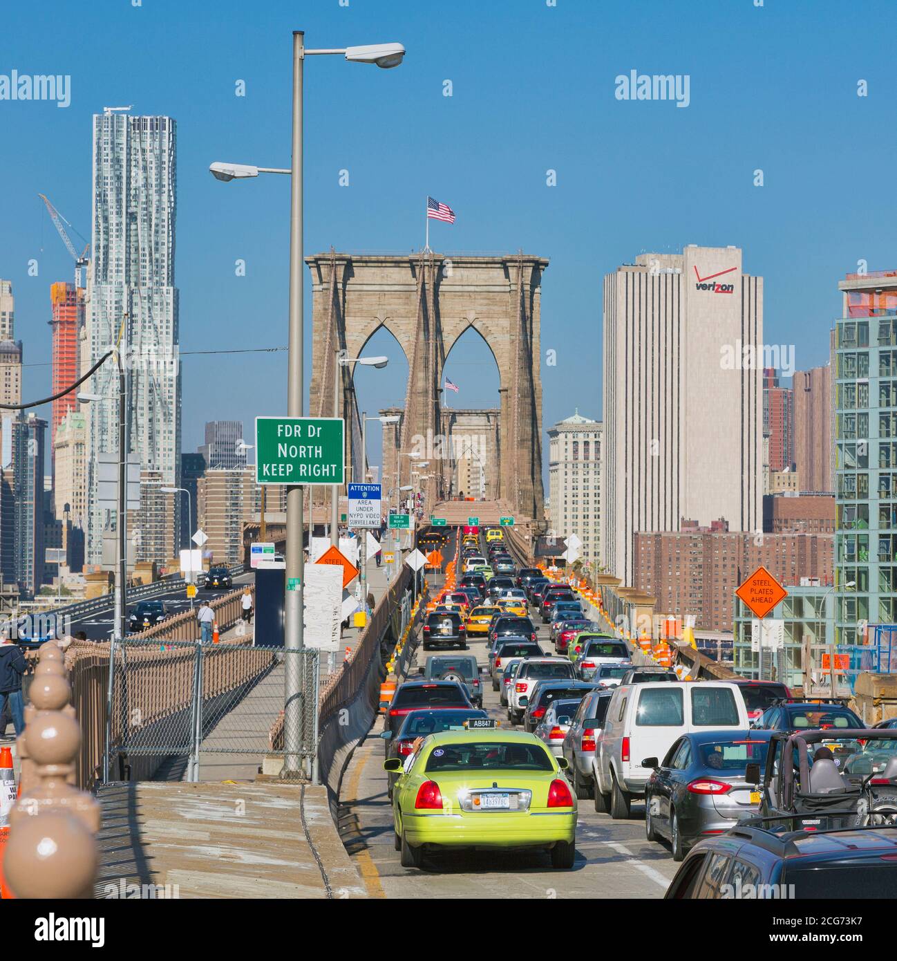 New York, New York State, Vereinigte Staaten von Amerika. Starker Morgenverkehr, der die Brooklyn Bridge von der Brooklyn-Seite aus erreicht. Manhattan im Hintergrund. Stockfoto