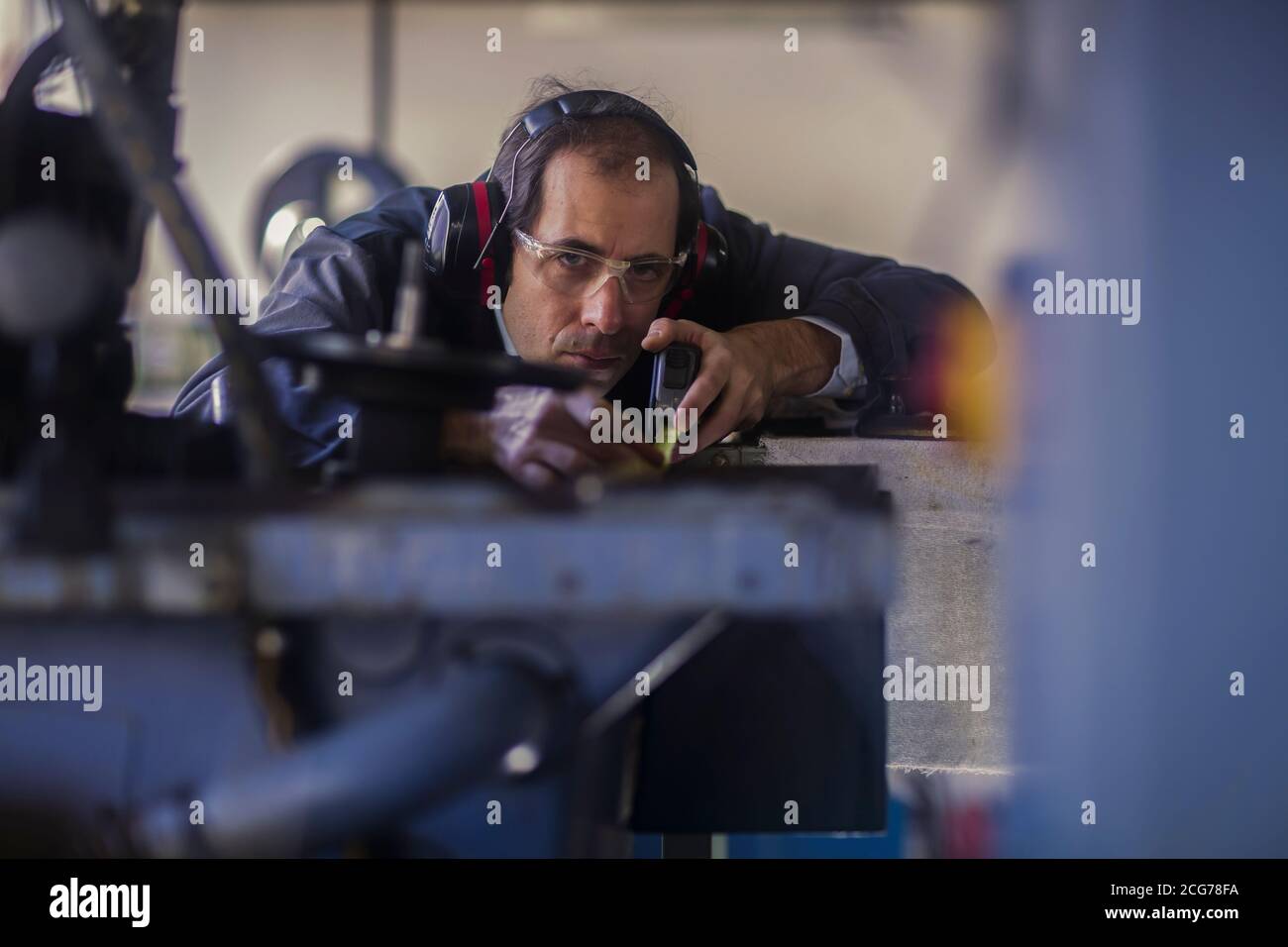 Ingenieur, der ein Maschinenteil in einer Industrieanlage inspiziert, Deutschland Stockfoto