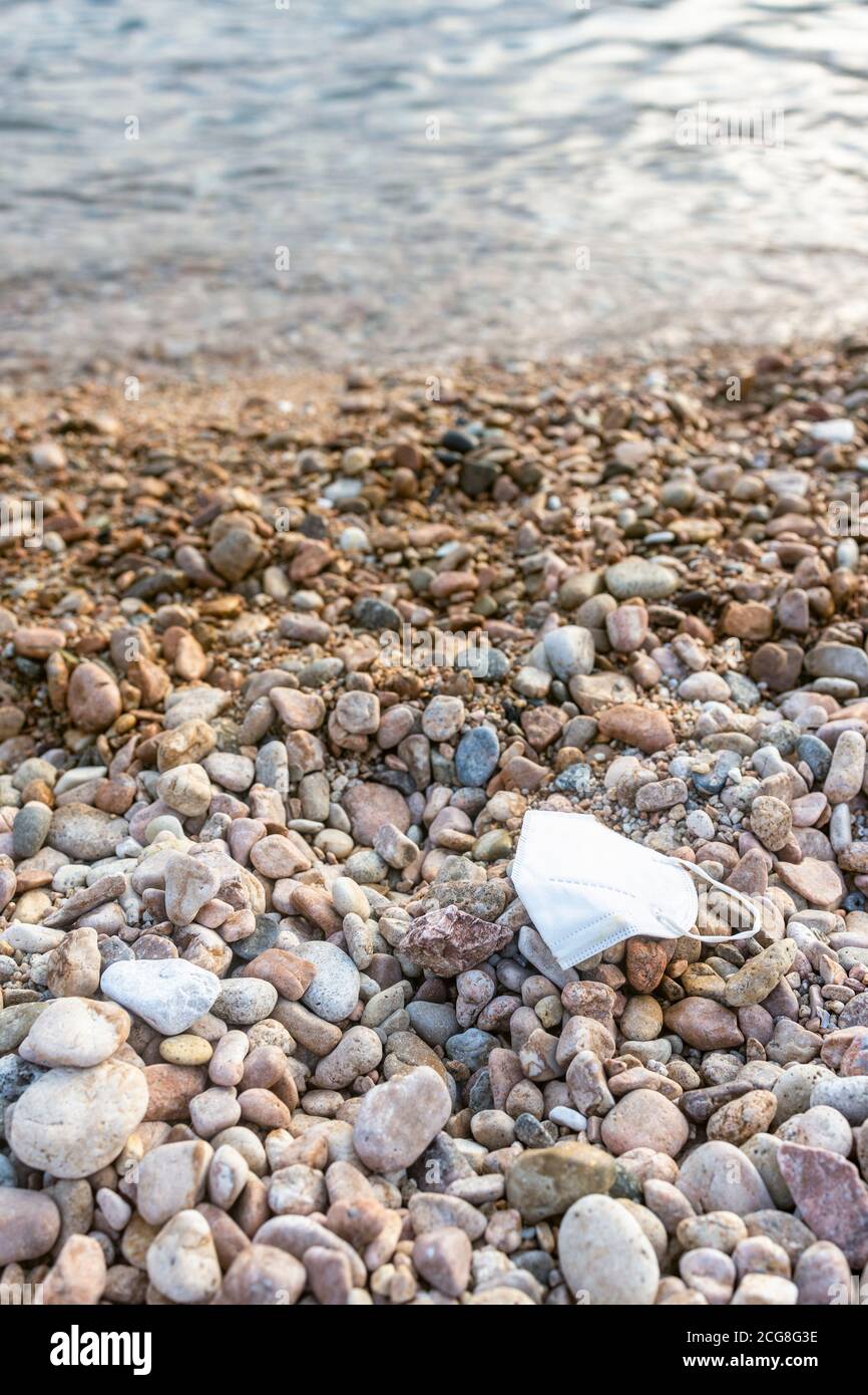 Verlorene Gesichtsmaske am Strand Stockfoto