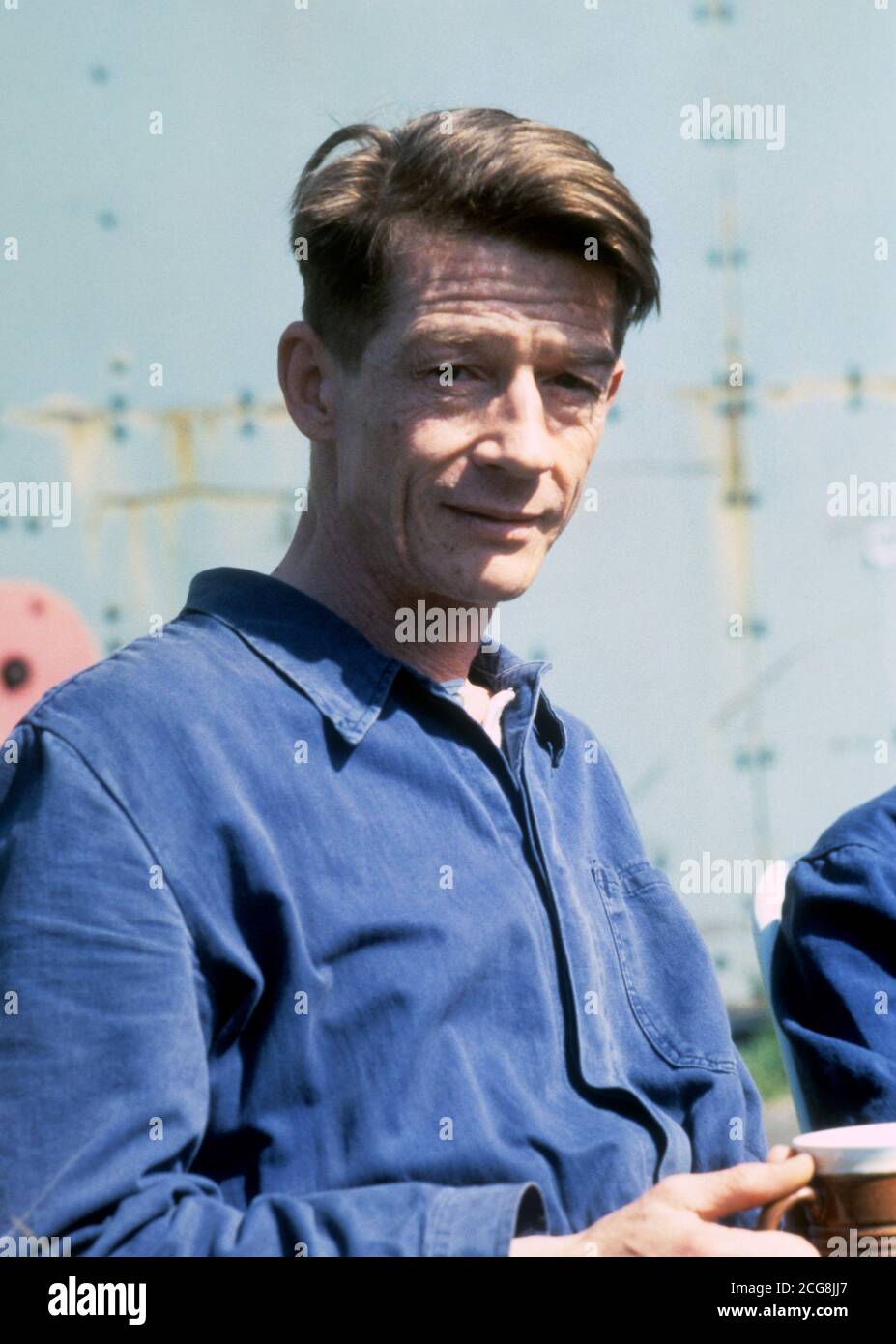 Schauspieler John Hurt hat eine Kaffeepause während der Dreharbeiten zu '1984' im RAF Hullavington, Wiltshire. Stockfoto