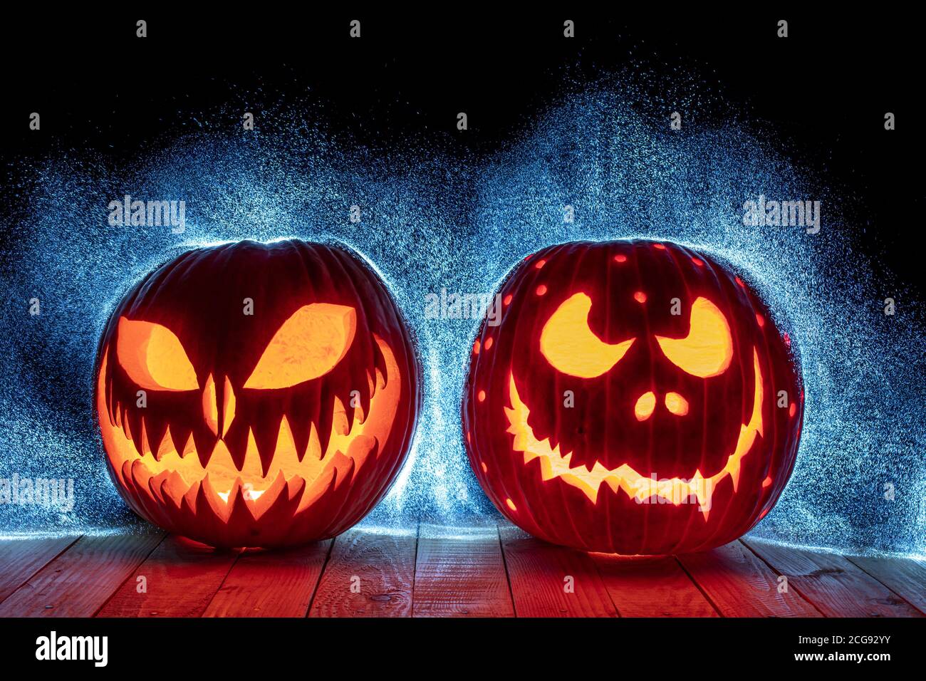 Geschnitzte halloween Kürbisse auf Holzsockel und Hintergrund mit Punktlicht. Stockfoto