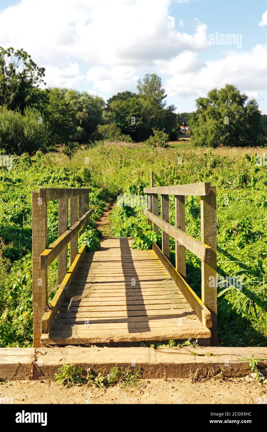 Eine hölzerne Fußgängerbrücke auf dem Canal Walk zum ausgedient North Walsham und Dilham Canal in North Walsham, Norfolk, England, Vereinigtes Königreich. Stockfoto