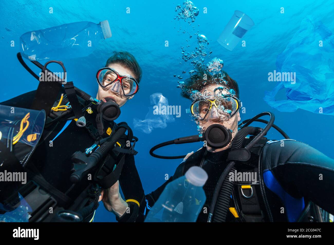 Junge Frau und Mann Taucher, Konzept der globalen Problem mit Plastikmüll schwimmt in den Ozeanen. Stockfoto