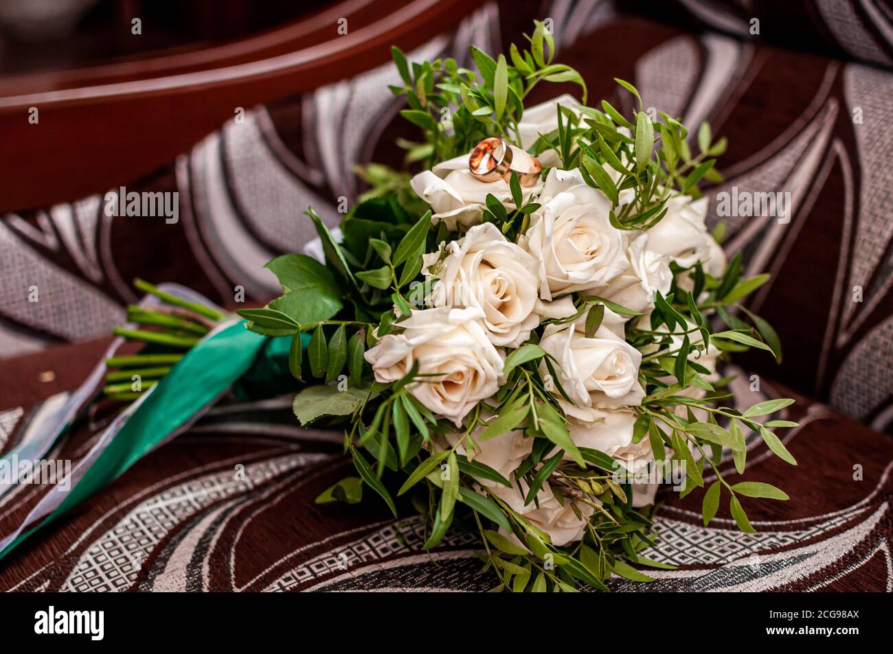 brautstrauß aus weißen Rosen mit Eheringen Stockfoto